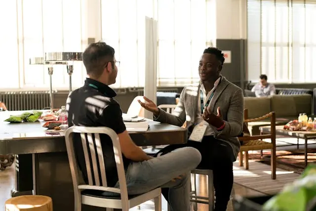 dos personas conversando en oficina